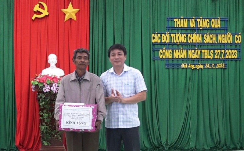 Đồng chí Huỳnh Quốc Huy tặng quà, động viên ông A Way - người có công tiêu biểu. Ảnh: MT