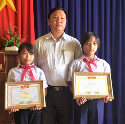 Ban giám hiệu Trường Phổ thông DTBT THCS xã Đăk Man tặng giấy khen cho em Y Dạu và em Y Ải (baokontum.com.vn)