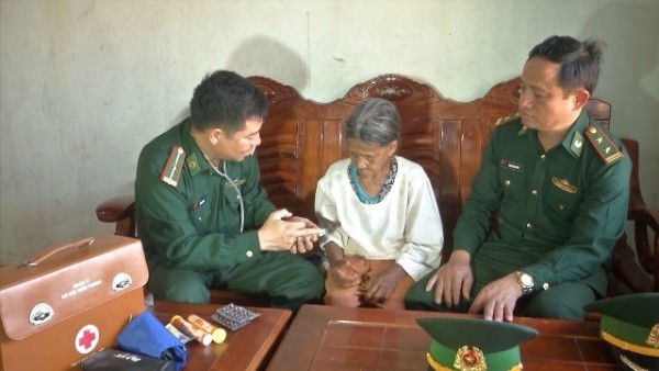 Trung tá Phan Trọng Bình cùng với Quân y đơn vị cấp thuốc, chăm sóc sức khỏe cho Cụ Y Huynh ở thôn Giang Lố I, xã Sa Loong