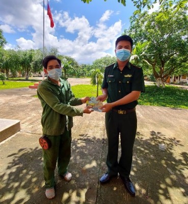 Thiếu úy Võ Việt Anh (bìa phải) trả lại vật rơi cho anh Hà Văn Yết